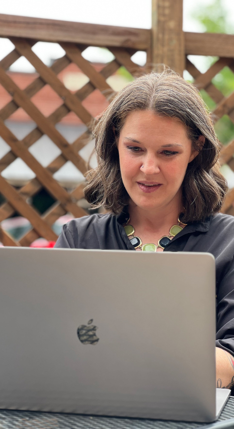 Amy Townsend working on computer outdoors
